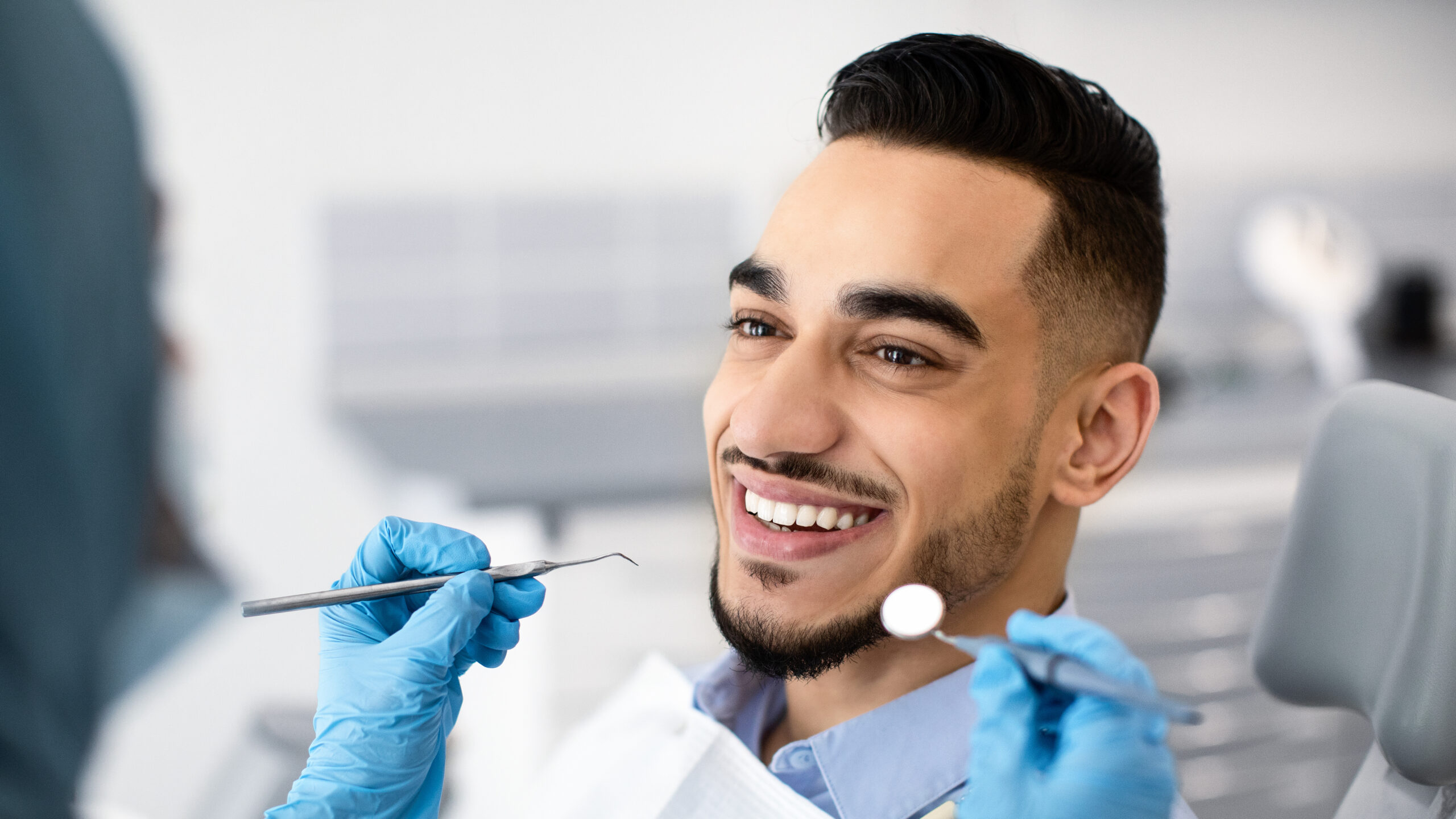 Closeup Of Happy Middle Eastern Man Patient Getting Dental Treatment In Modern Clinic