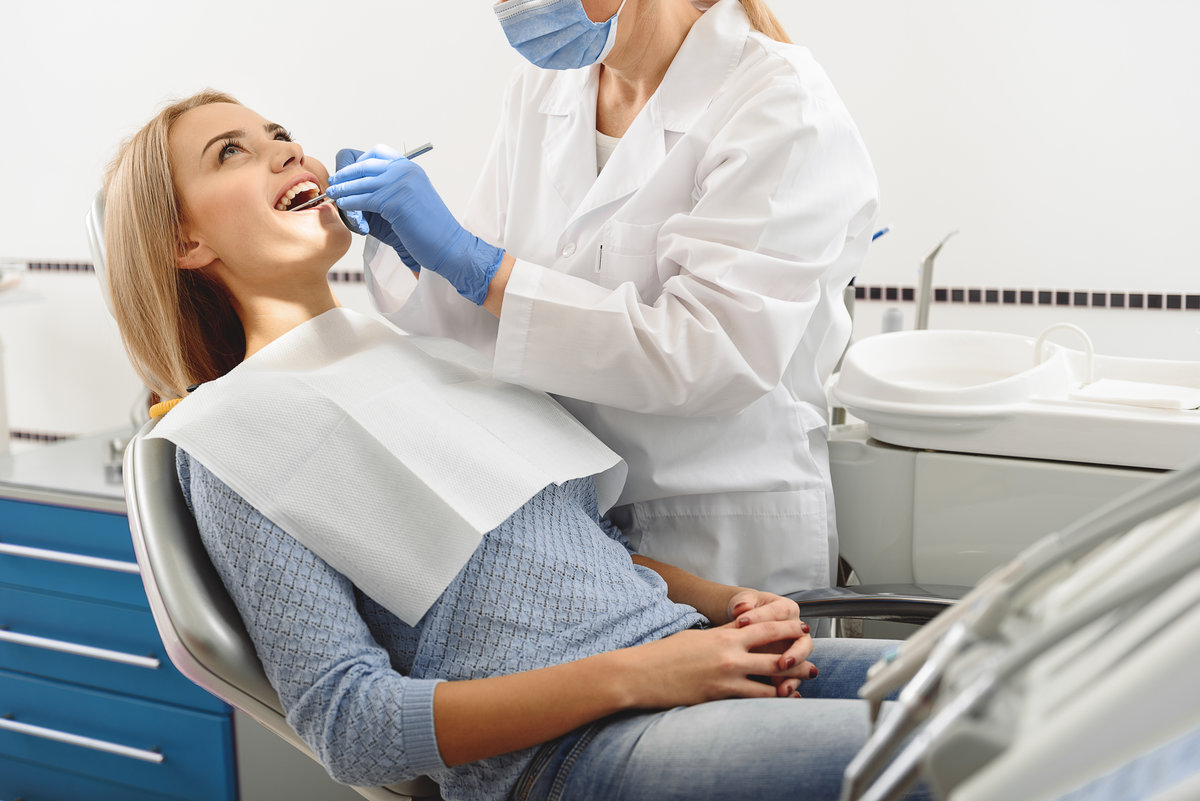 Stomatlogist working with instruments in mouth of client
