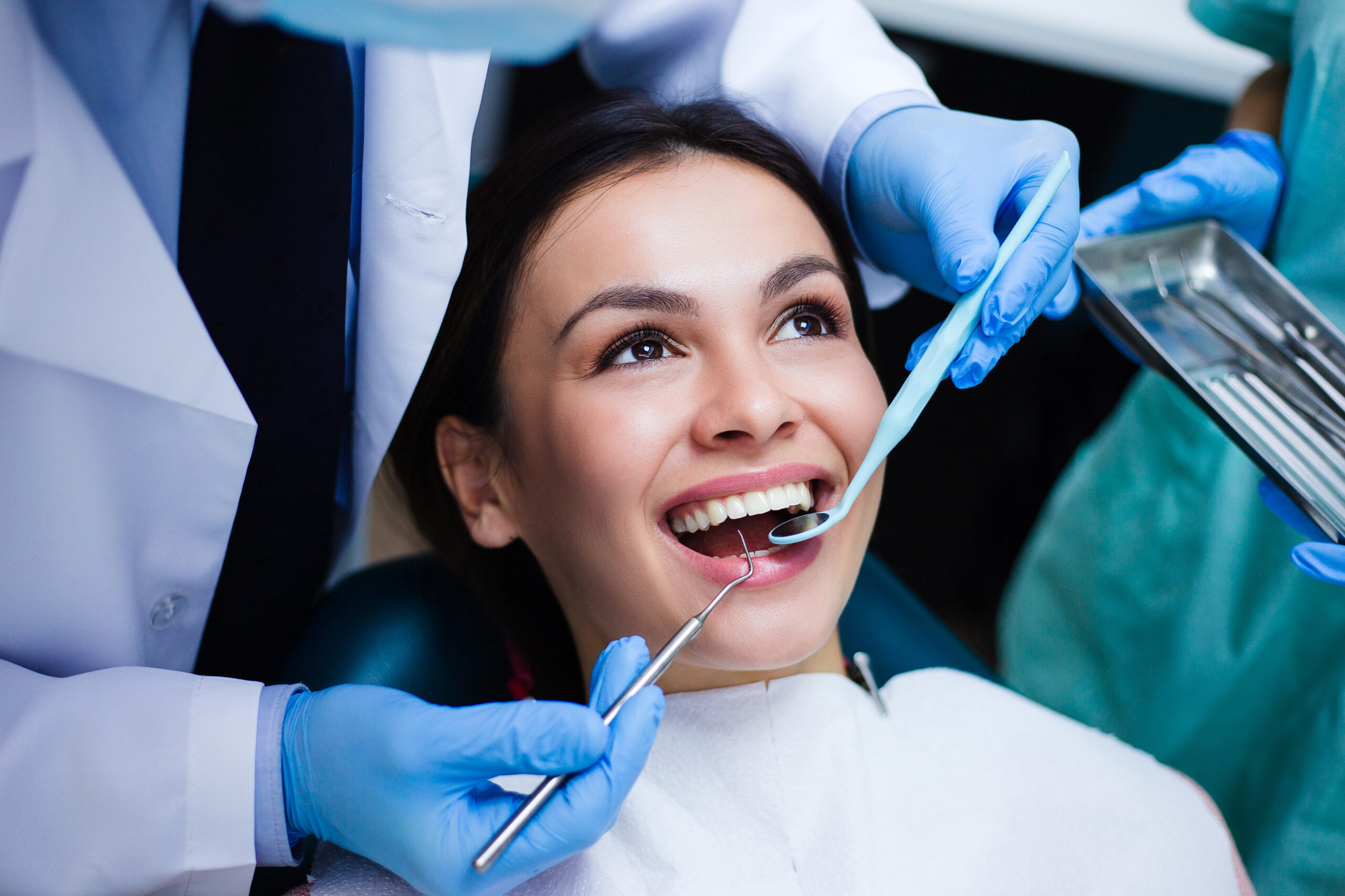 Perfect smile! Part of dentist examining his beautiful patient in dentist’s office