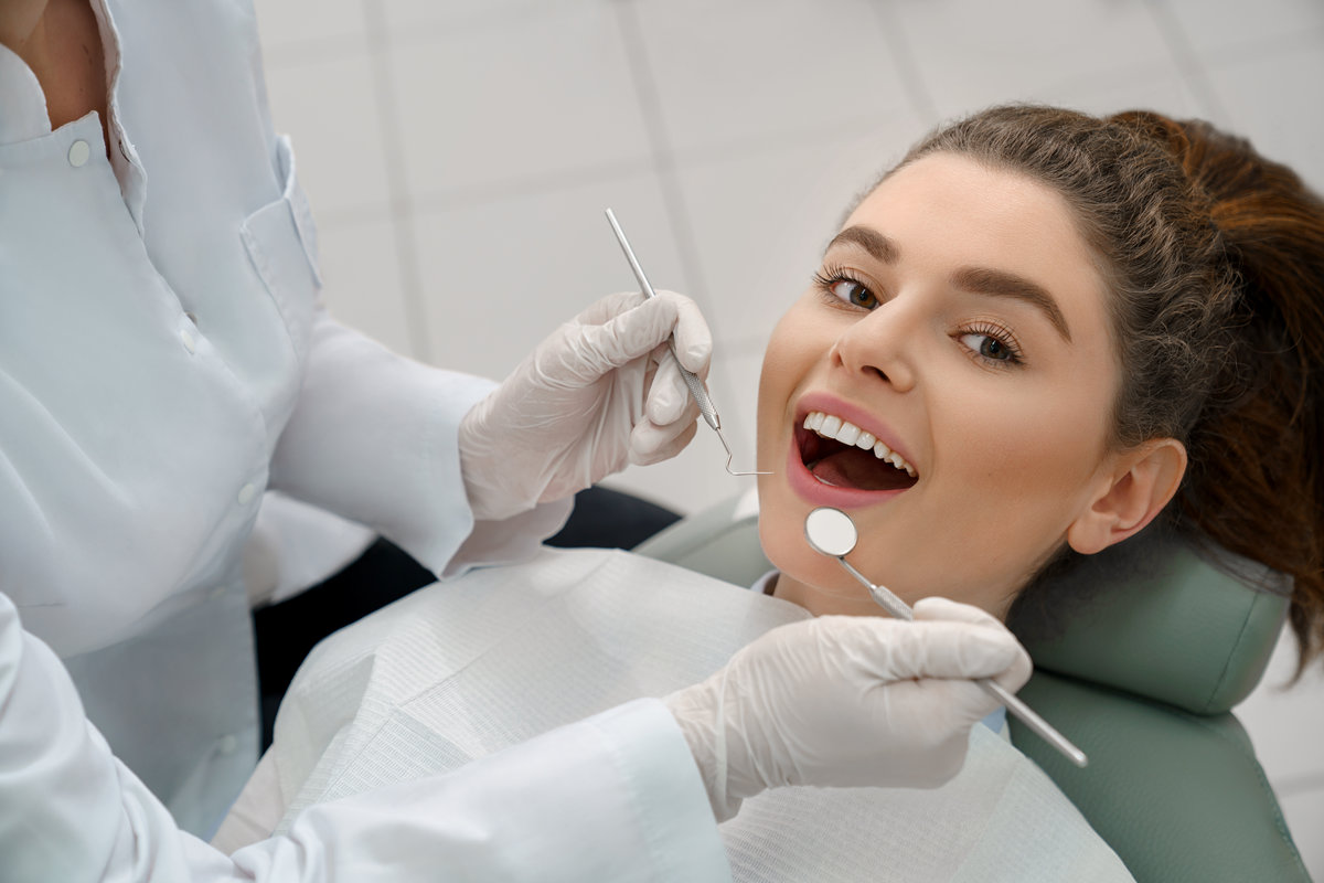 Woman with open mouth looking at camera in dental office