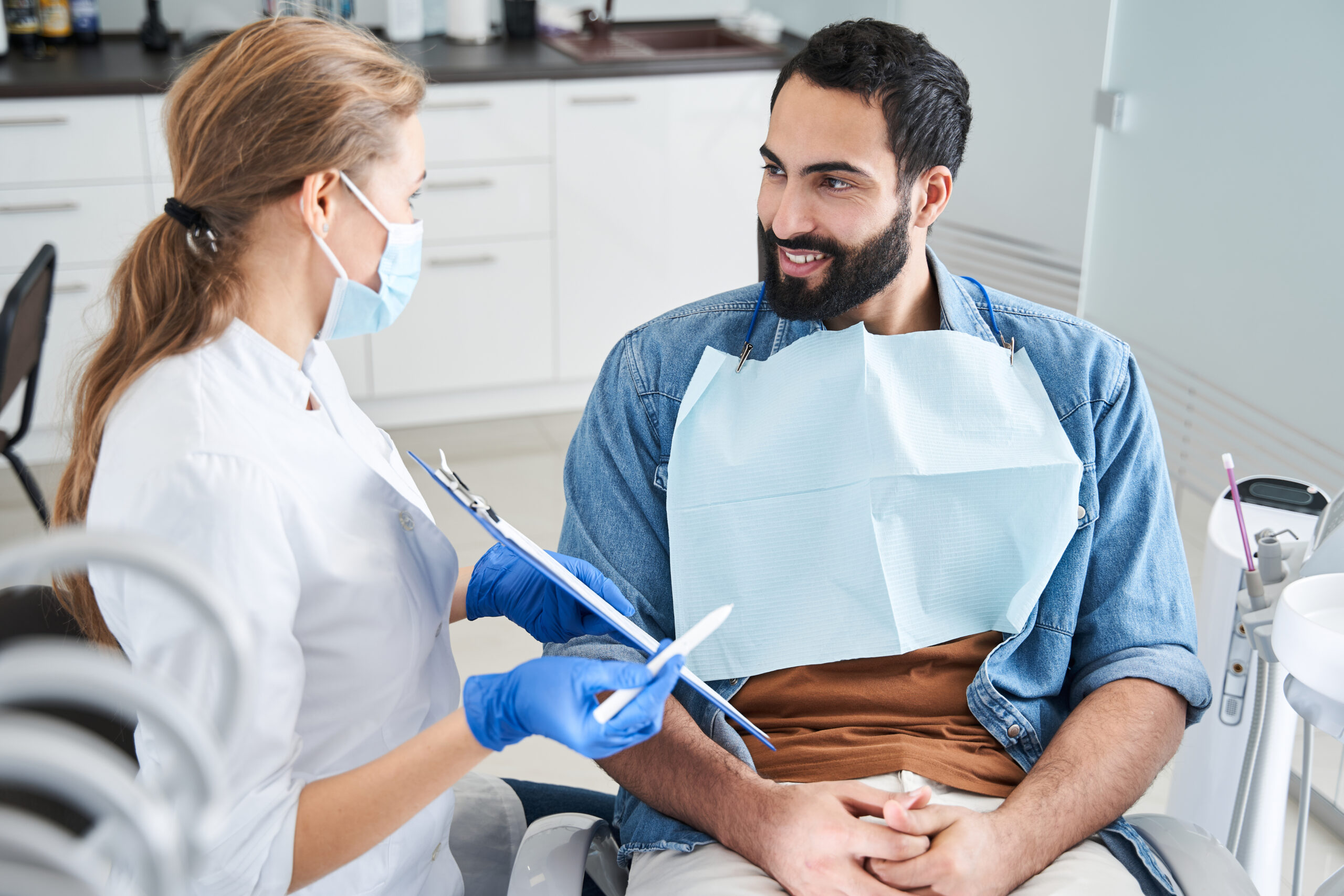Dentist showing the paper to a smiling man client
