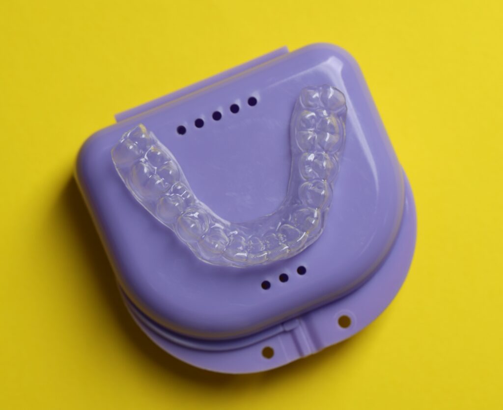 one clear aligner and retainer case on yellow back 2026 06 16 06 30 21 utc